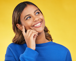 Image showing Thinking, happy and young woman in a studio with a dreaming, idea or brainstorming facial expression. Smile, happiness and Indian female model with a planning or decision face by a yellow background.