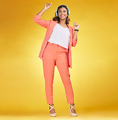 Image showing Woman, headphones and happy dance to music in studio for fashion, freedom and audio energy on yellow background. Indian model, style and dancing to celebration, listening to radio and streaming sound