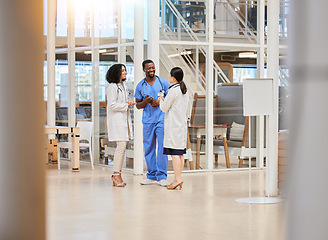 Image showing Group of doctors, nurses and people talking in hospital lobby, discussion and communication. Team, medical professional and happy black man and women smile in conversation, chat or healthcare meeting