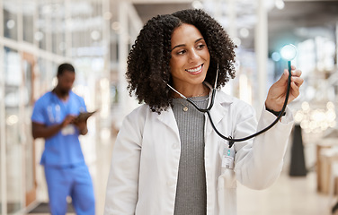 Image showing Woman, doctor and stethoscope with thinking, hospital and smile for check, overlay and light in corridor. African medic, tools and happy for healthcare job, service and listening with glow in clinic