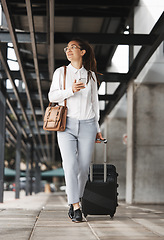 Image showing Phone, travel and suitcase with a business woman in an airport parking lot walking outdoor in the city. Mobile, luggage and commute with a young corporate professional on an international work trip
