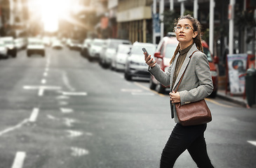 Image showing Smartphone, business woman and cross street for journey, sunset commute and social media on internet. Mobile, consultant and person walking in city on phone for networking, cbd travel and lens flare