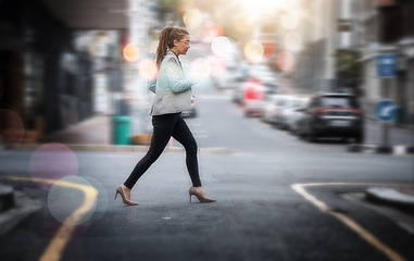 Image showing Walking, business and a woman crossing a street in the city while in a rush or late for work. Road, pedestrian and travel with a young female employee on her commute in an urban town for opportunity