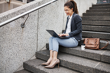 Image showing Business woman, stairs and typing on laptop, planning schedule and thinking with ideas, copywriting or city. Young entrepreneur, smile and sitting on steps with computer for remote work in metro cbd