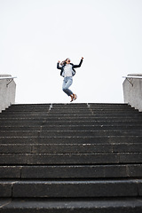Image showing Business person, stairs and jump for celebration, success and goals in finance career, investment and stock market. Young woman, winner and fist in air for achievement, pride or lottery on city steps
