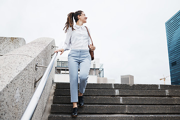 Image showing Business, woman and walking on city building steps happy, smile and looking while traveling. Travel, walk and female person smile for commute, thinking and enjoying solo trip in New York outdoor