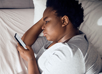 Image showing Stress, morning or black woman in bed with phone for social media lying in room for addiction at home. Insomnia, lonely or sad person reading online to scroll on mobile app in bedroom with depression