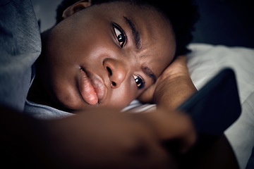 Image showing Insomnia, night and black woman in bed with phone for social media lying in room for addiction at home. Stress, lonely or sad person reading online to scroll on mobile app in bedroom with depression