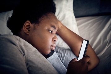 Image showing Insomnia, night and black woman in bedroom with mobile for social media lying in for addiction at home. Stress, lonely or sad person reading online to scroll on phone app in bedroom with depression