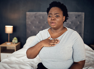 Image showing Fear, sick and a black woman with an anxiety attack or pain in chest from stress. Scary, health and an African girl on a bed with panic, depression or a mental health illness or fail in the bedroom