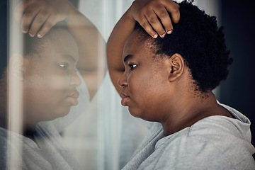 Image showing Reflection, thinking and black woman with depression in a house with anxiety or a mental health idea. Window, anxiety and an African girl or person with vision of life while frustrated from a mistake