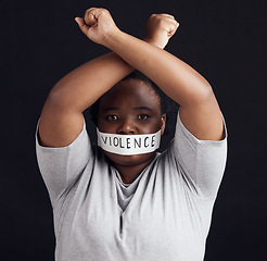 Image showing Portrait, freedom and a black woman in protest of domestic violence on a dark background. Censorship, gender equality or empowerment with a serious young female person in studio for human rights