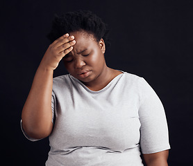 Image showing Sad black woman, headache and stress in studio of anxiety, trauma risk and worry on dark background. Frustrated, confused and depressed model with burnout, brain fog and fear, pain and mental health