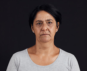 Image showing Senior woman, portrait and mental health, depression and crisis with abuse isolated on black background. Sad, angry and anxiety with depressed female person, serious face and grief in a studio