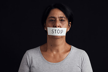 Image showing Portrait, stop and censorship with a woman in studio on a black background for gender equality or domestic violence. Face, silence or abuse and a scared female victim with her mouth covered in fear