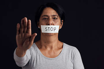 Image showing Portrait, stop and palm with a woman in studio on a black background for gender equality or domestic violence. Hand, silence or abuse and a scared female victim with her mouth covered in fear
