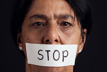 Image showing Portrait, stop and silence with a woman in studio on a black background for gender equality or domestic violence. Face, censorship or abuse and a scared female victim with her mouth covered closeup