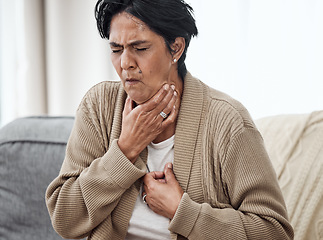 Image showing Senior woman, cough and sick on sofa in home, chest pain and pneumonia with tuberculosis or choke. Pensioner, mature lady or sore throat with lung infection, breathing problem and choking with asthma