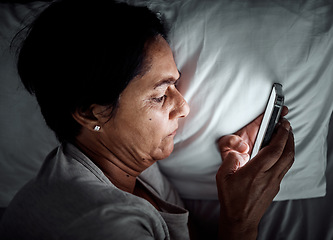 Image showing Insomnia, night and smartphone with senior woman in bedroom for social media app, dark and addiction. Communication, contact and internet with female person in bed at home with stress and online chat