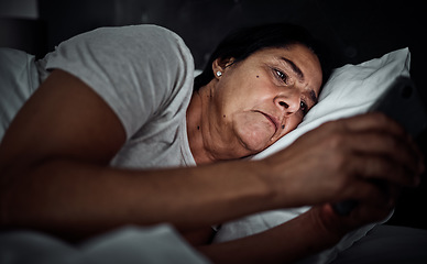 Image showing Insomnia, night and phone with old woman in bed for social media, thinking and communication. Tired, fatigue and relax with senior person in bedroom at home for mobile app, streaming and contact