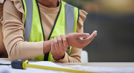 Image showing Industry, closeup and female construction worker with wrist pain, injury or accident in her office. Medical emergency, engineering and zoom of a woman industrial employee with a sprain hand muscle.