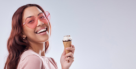 Image showing Fashion, ice cream and portrait of woman with sunglasses in studio with dessert, snack and sweet treats. Happy, smile and face of female person with cone in trendy accessories, style and cosmetics