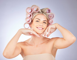 Image showing Hair care, rollers and portrait of woman in a studio doing a natural, beautiful and curly hairstyle. Self care, happy and attractive female model with curlers for beauty isolated by a gray background