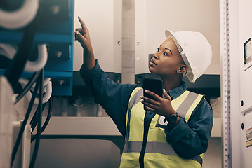 Image showing Black woman, engineering technician and phone in control room to connect system, mechanic industry or machine maintenance. Female electrician, mobile technology or check power at electrical generator