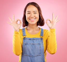 Image showing Smile, okay and yes with portrait of woman in studio for support, agreement and motivation. Winner, emoji and success with face of person on pink background for achievement, thank you and vote sign
