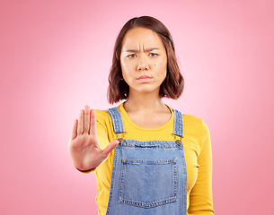 Image showing Woman, palm and stop in studio portrait with angry face, rejection or bad review by pink background. Gen z student girl, sign or emoji for protest, voice or opinion for feedback, activism or warning