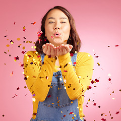 Image showing Portrait, celebration and woman blow confetti to celebrate winner announcement, congratulations and New Years cheers. Studio, winning or Asian person happy for birthday party event on pink background