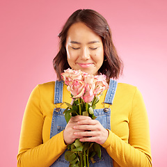 Image showing Woman, smell roses and gift in studio, smile and excited for celebration, birthday or party by pink background. Japanese student girl, thinking and bouquet of flowers for present, reward or romance