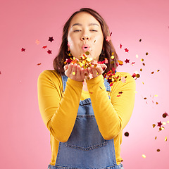 Image showing Portrait, celebration and Asian woman blow confetti to celebrate winner, happiness and excited at party event. Studio color, wow and creative Japanese person happy for birthday on pink background