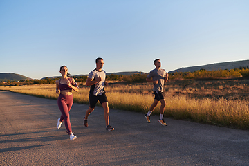 Image showing A group of young athletes running together in the early morning light of the sunrise, showcasing their collective energy, determination, and unity