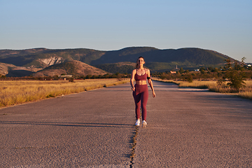 Image showing Healthy young couple jogging in the city streets in the early morning with a beautiful sunrise in the background