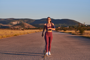 Image showing Healthy young couple jogging in the city streets in the early morning with a beautiful sunrise in the background