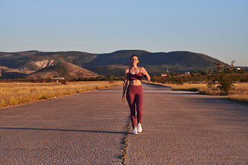 Image showing Healthy young couple jogging in the city streets in the early morning with a beautiful sunrise in the background