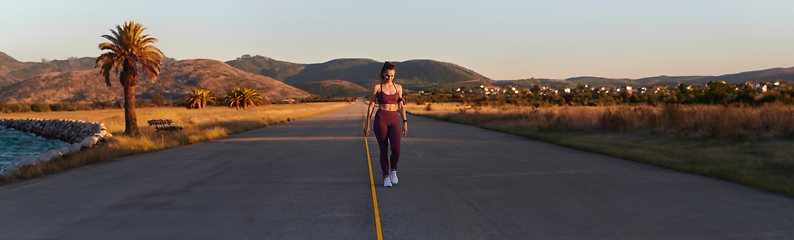 Image showing Healthy young couple jogging in the city streets in the early morning with a beautiful sunrise in the background