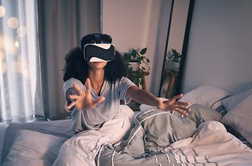 Image showing Woman, bed and vr game in night, home and online in metaverse, matrix and stretching hands for challenge. Girl, augmented reality glasses and vision for 3d user experience, dark bedroom and apartment