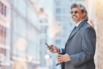 Image showing Senior, business man and smartphone in city, travel and commute, bokeh and communication outdoor. Mexican male executive, CEO using phone on journey to work and urban street with mockup space