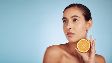 Image showing Woman, orange and vitamin C on mockup for diet or skincare against a blue studio background. Female person, model or beauty with organic citrus fruit for natural nutrition, spa or facial treatment