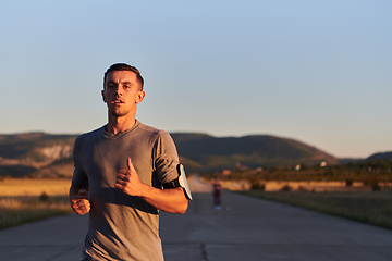 Image showing A young handsome man running in the early morning hours, driven by his commitment to health and fitness