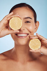 Image showing Happy woman, skincare portrait and lemon for beauty, cosmetics, natural facial product and vitamin c benefits. Face of young person or model with fruits for eye dermatology on studio, blue background