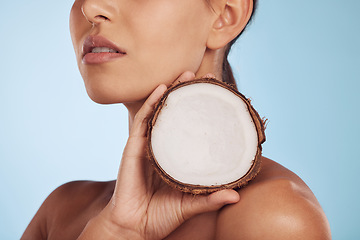 Image showing Woman, coconut fruit and beauty, skincare or vegan cream isolated studio, blue background. Model or person hands with natural product for dermatology, eco friendly cosmetics and oil benefits