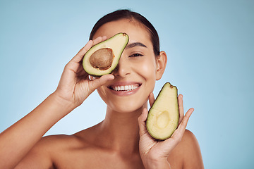 Image showing Avocado, eye beauty and woman in portrait, healthy face and natural skincare on studio blue background. Happy person or model with green fruits, vitamin d benefits and dermatology or cosmetics health