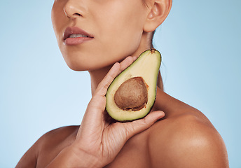 Image showing Skincare, beauty and woman with avocado, natural makeup and facial detox on blue background. Health, wellness and closeup of model, organic luxury cleaning and cosmetics with fruit in hand in studio