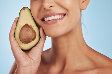 Image showing Skincare, beauty and smile, woman with avocado, natural makeup and facial detox on blue background. Health, wellness and mouth of model, organic luxury cleaning and cosmetics with fruit in studio.