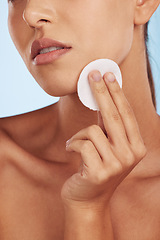 Image showing Woman, hands and cotton pad for skincare, makeup removal or cosmetics against a blue studio background. Closeup of female person with round swab or patch for cleaning, hygiene or facial spa treatment