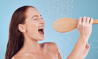 Image showing Happy woman, shower and singing with brush for hygiene, cleaning or self love and body care against a blue studio background. Female person enjoying water, rain or wash for cleanliness or grooming