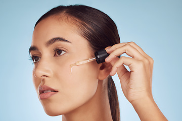 Image showing Face, skincare and woman with serum dropper for beauty in studio isolated on a blue background. Cosmetics, model and essential oil, collagen and hyaluronic acid for dermatology, health and wellness